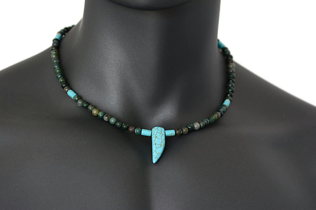A beaded choker necklace for men featuring blue howlite and Indian agate with a tusk horn pendant on a mannequin.